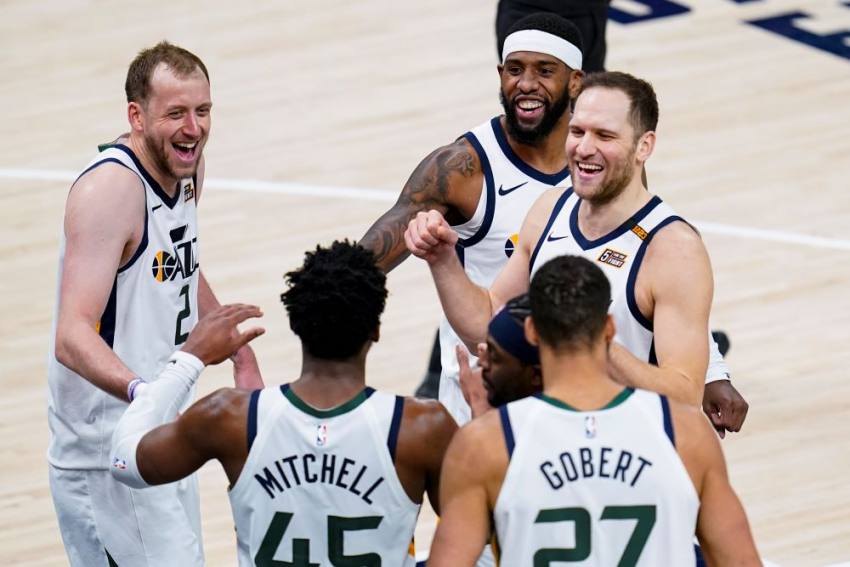 Members of the Utah Jazz share laughs and high-five Donovan Mitchell during their game.